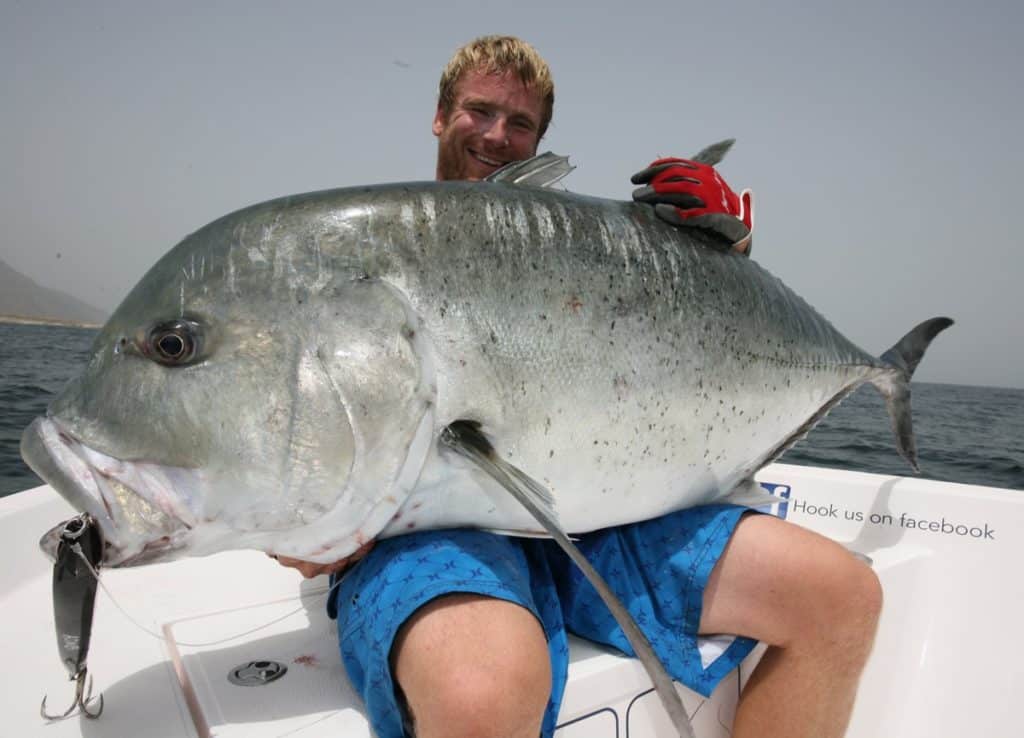 Angler with a huge giant trevally caught fishing in Oman