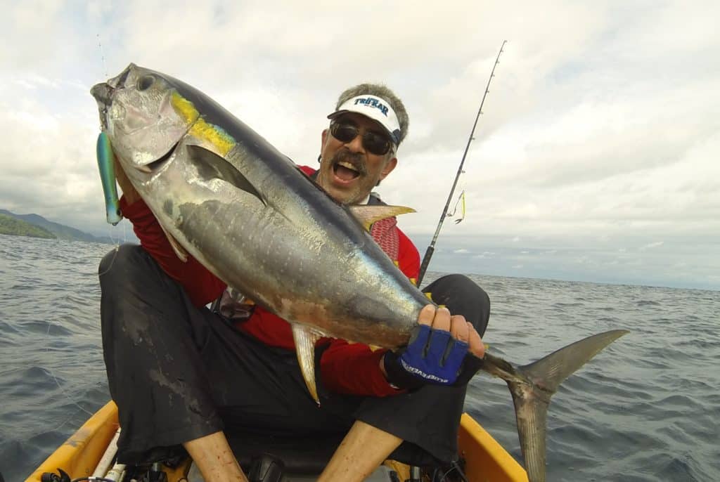 Angler grip and grin yellowfin tuna caught fishing Panama