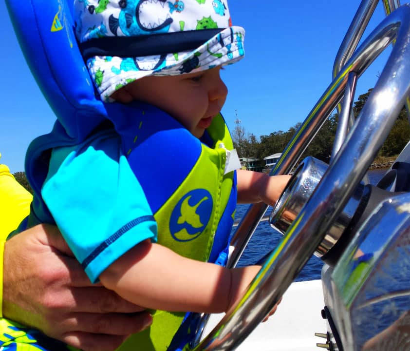 Infant wearing life jacket fishing boat Navy Point, Pensacola, Florida