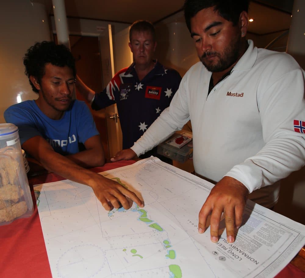 Fishermen looking at nautical charts during fishing