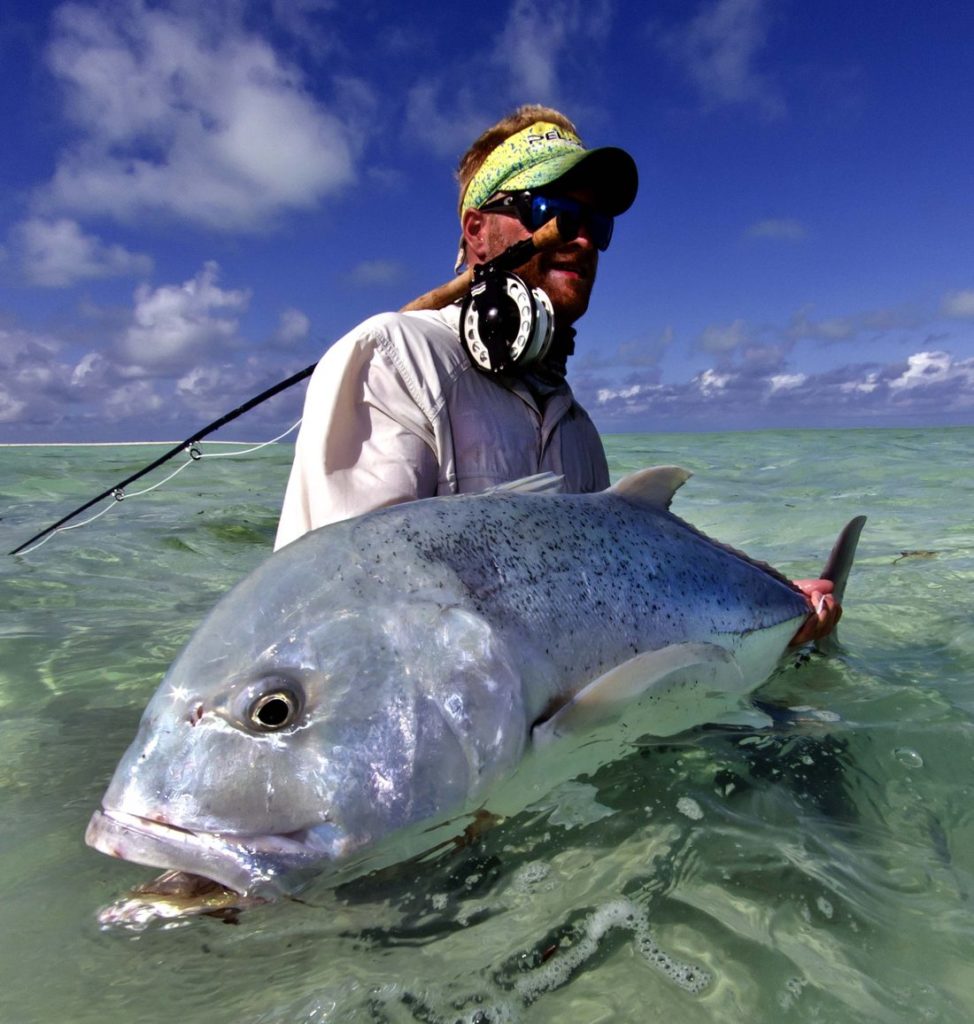 Angler holding a giant trevally fish (GT)