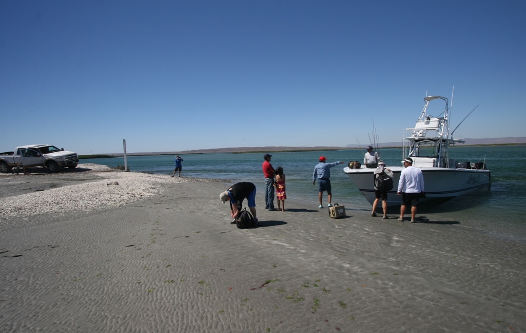 Anglers launching fishing boat into Pacific
