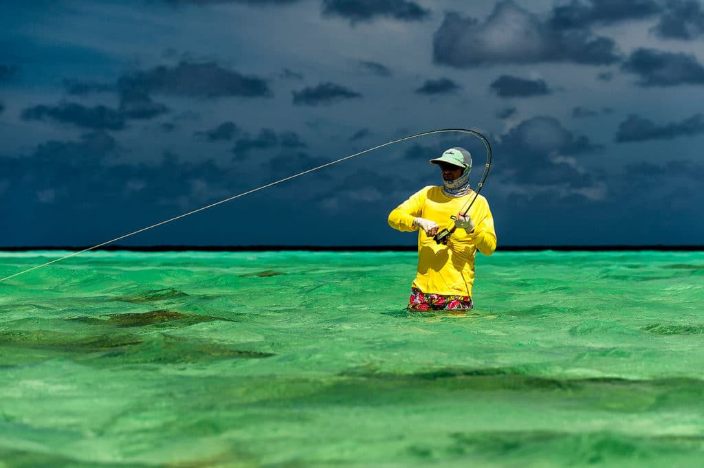 Dazzling fishing photography of Henry Gilbey - fighting a fish in front of a storm