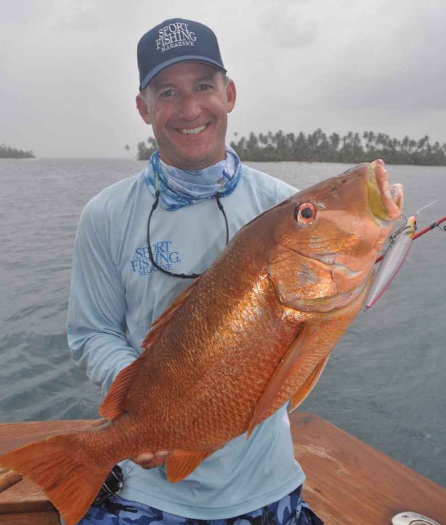 Angler holding a fish caught while twitching and fishing with a Shimano Orca pencil crankbait fishing lure