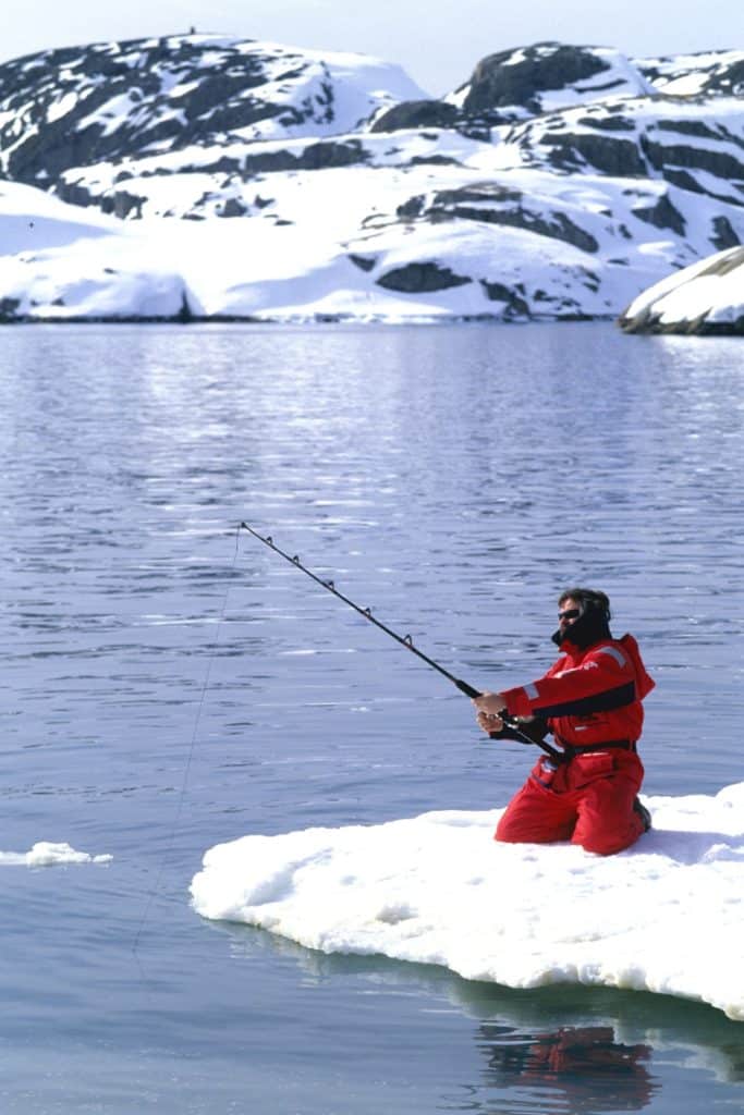 Ice fishing fisherman wearing survival suit