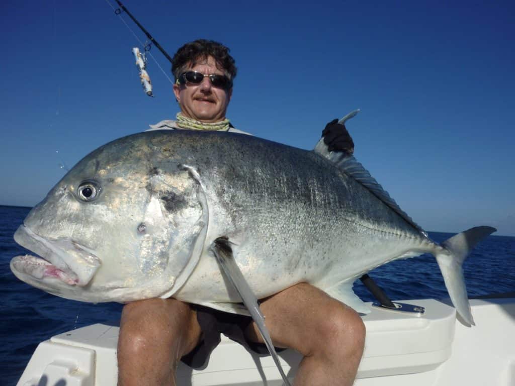 Angler holding a big giant trevally in New Caledonia