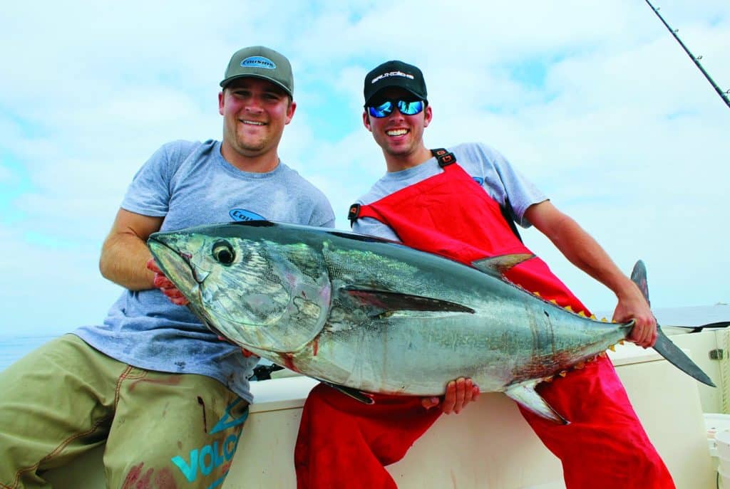 Fishermen grin and grab bluefin tuna fish Southern California