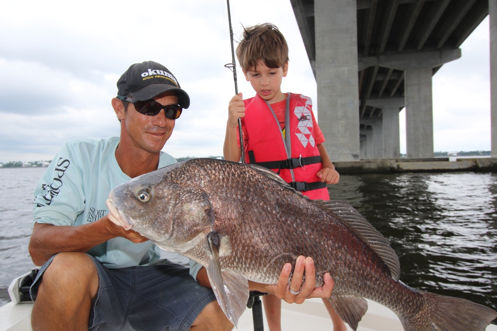 Small boy admires large black drum