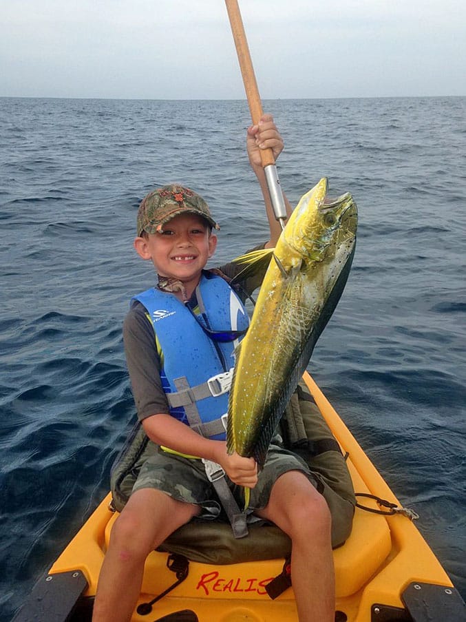 Boy wearing life jacket kayak fishing mahi Destin, Florida