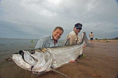 Two fishermen holding a giant tarpon caught in Angola