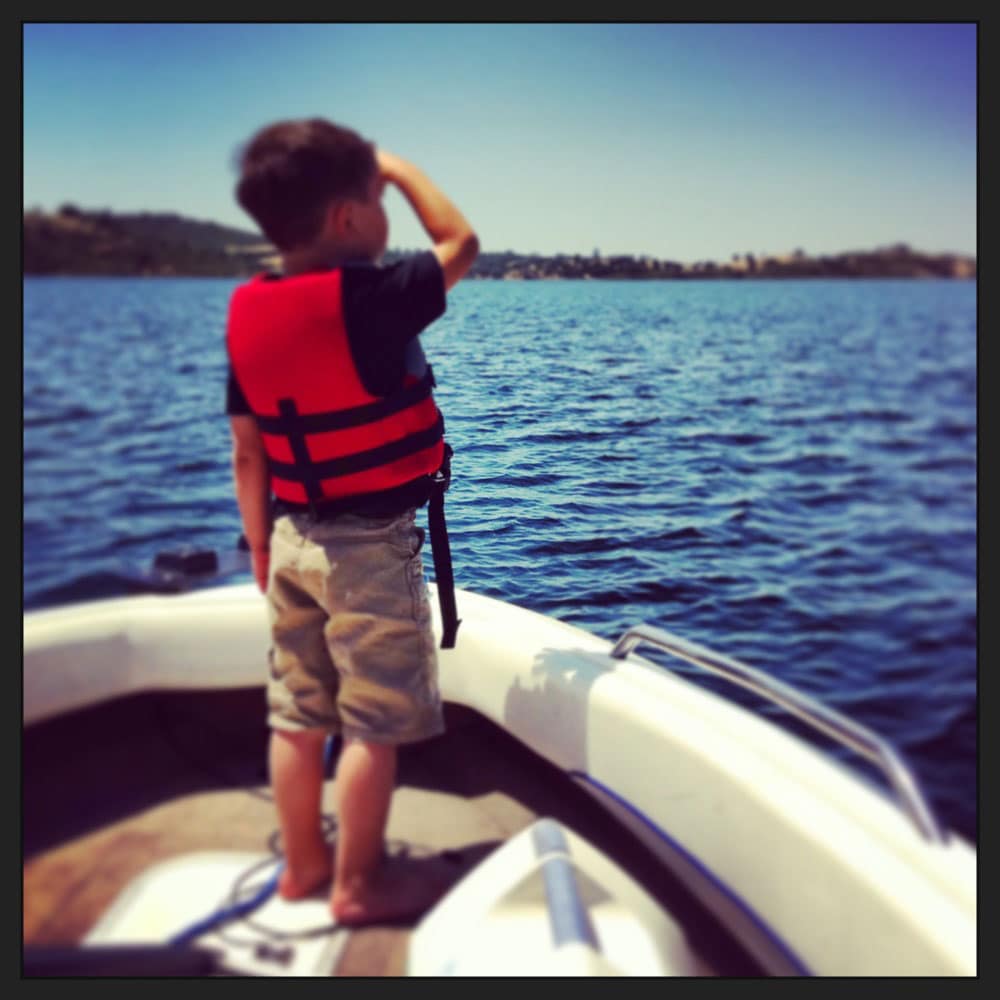 Boy wearing life jacket saluting Lake Camanche