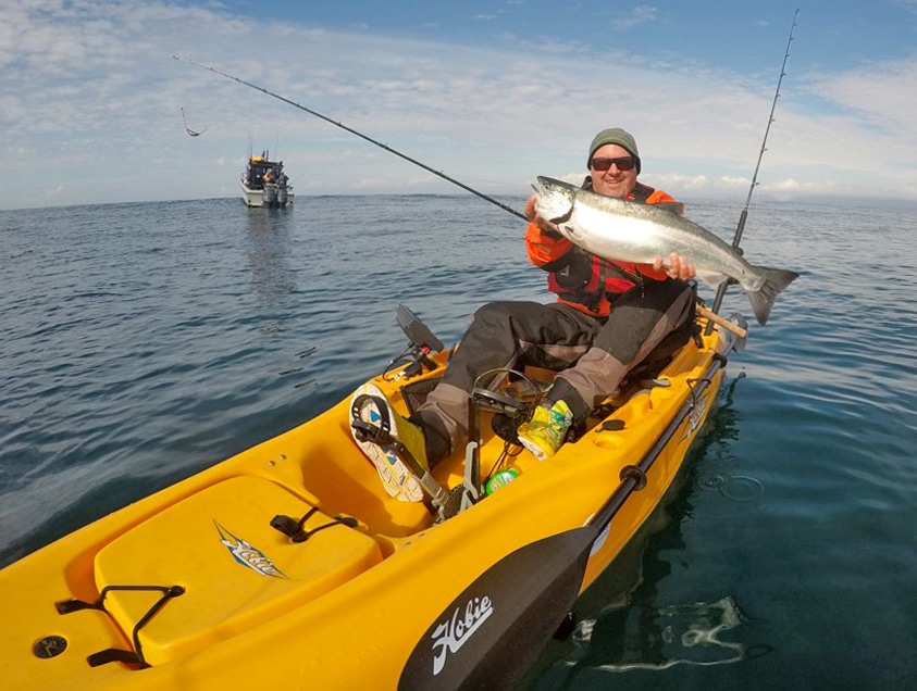 success -- angler lands large silver salmon in kayak