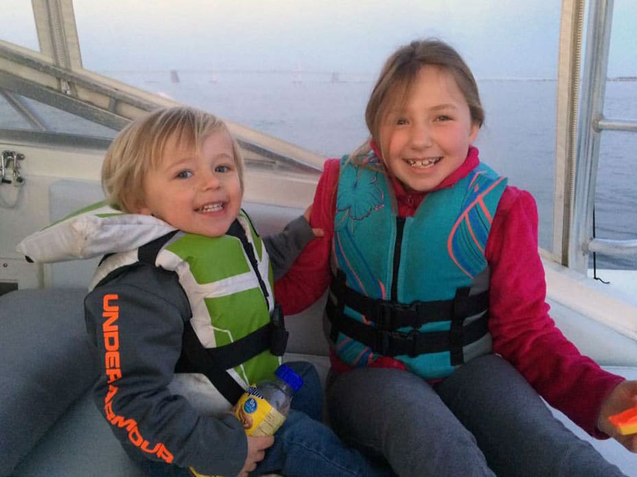 Boy and girl wearing life jackets on boat Chesapeake Bay at Magothy River