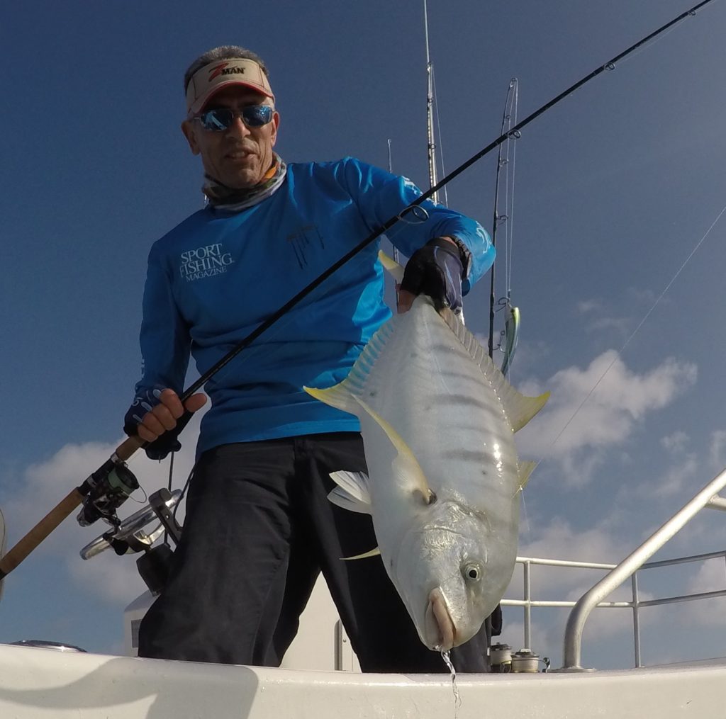 Angler holding big fish caught on fishing rod and reel using a twitchbait lure