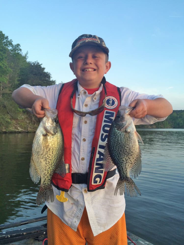 Boy wearing Mustad PFD holding fish Lay Lake, Alabama