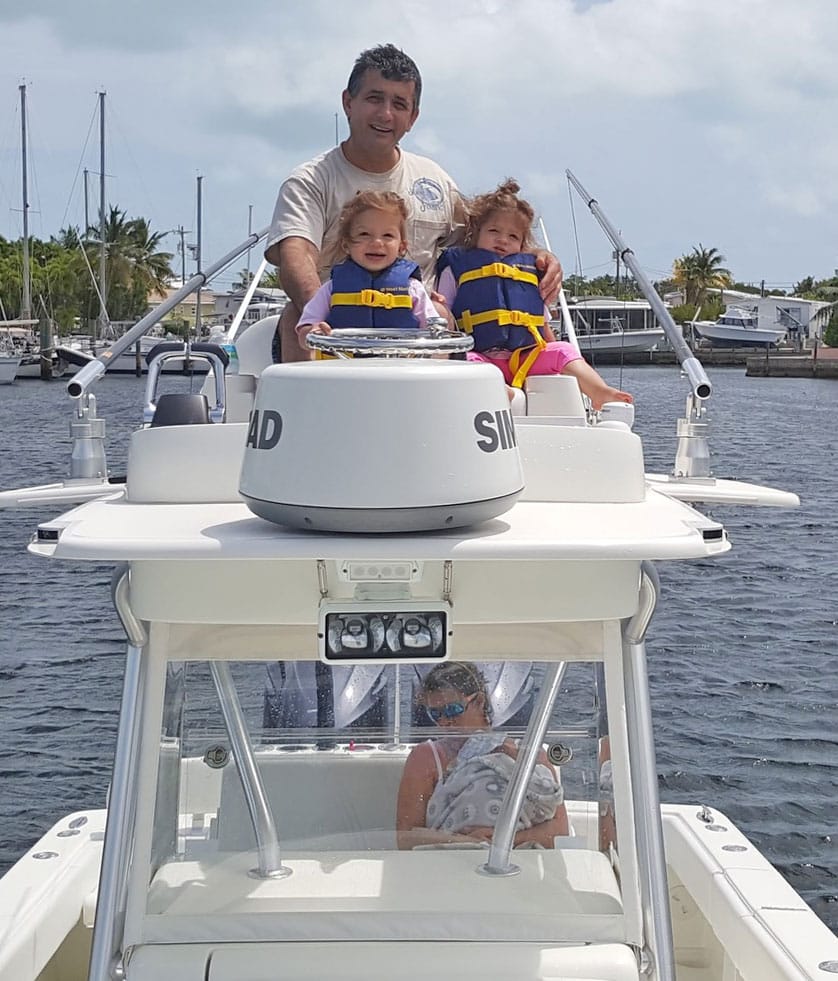 Sisters wearing life jackets with dad fishing boat Tavernier, Florida
