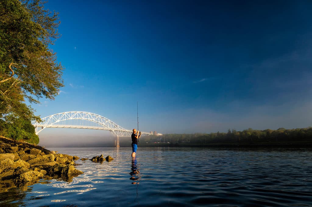 Dazzling fishing photography of Henry Gilbey - picture-perfect day for angler fishing Cape Cod Canal