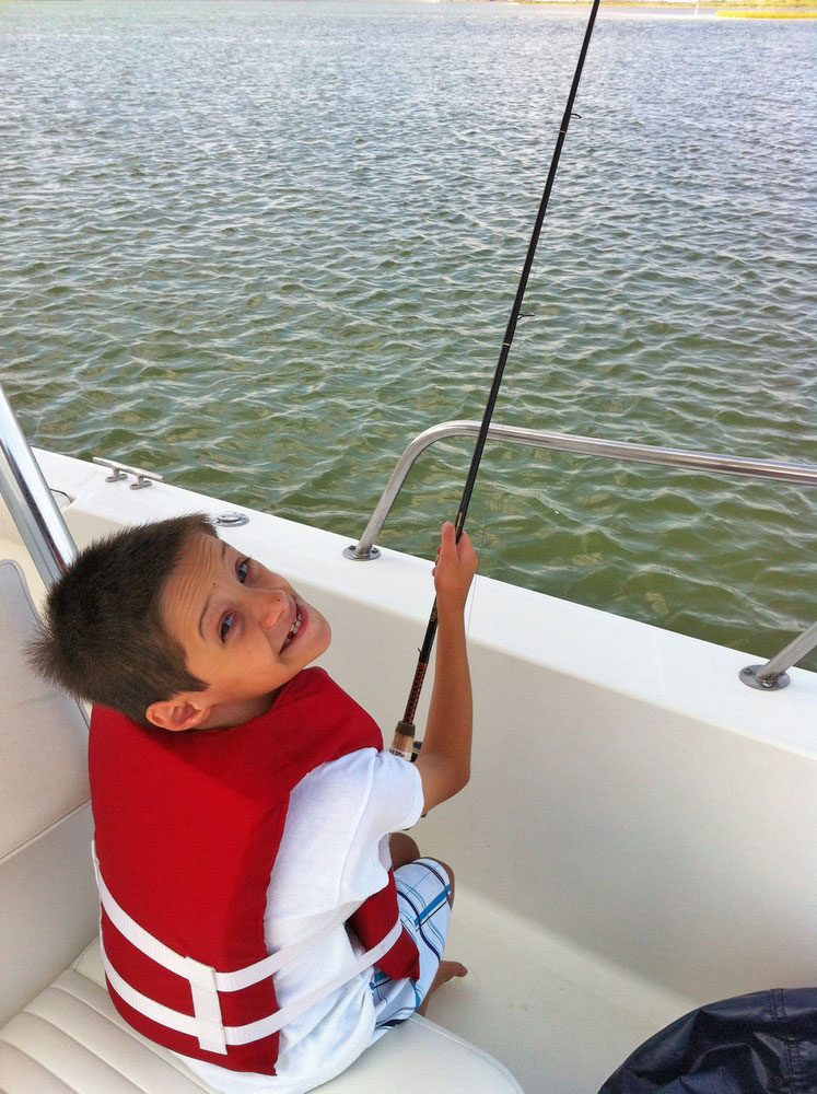 Boy wearing life jacket fishing Port Aransas, Texas