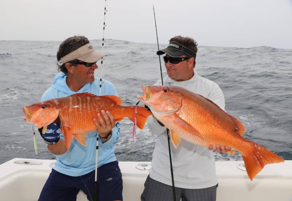 Fishermen hold up dog snapper fish caught fishing Panama