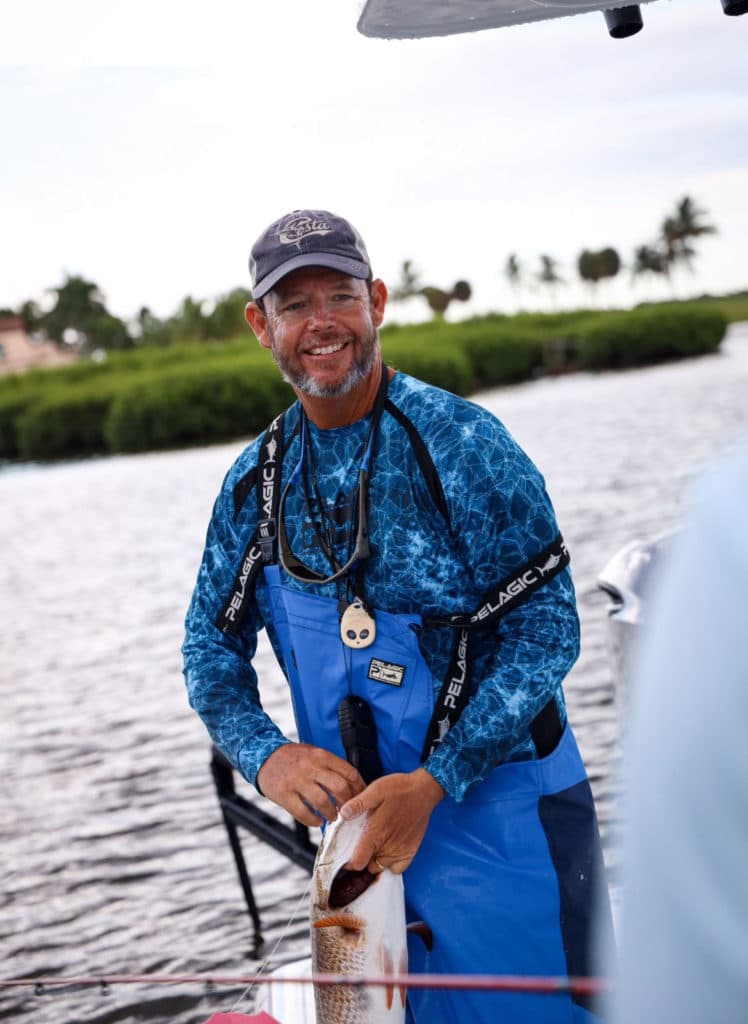 Capt. Ozzie Fischer holding a redfish