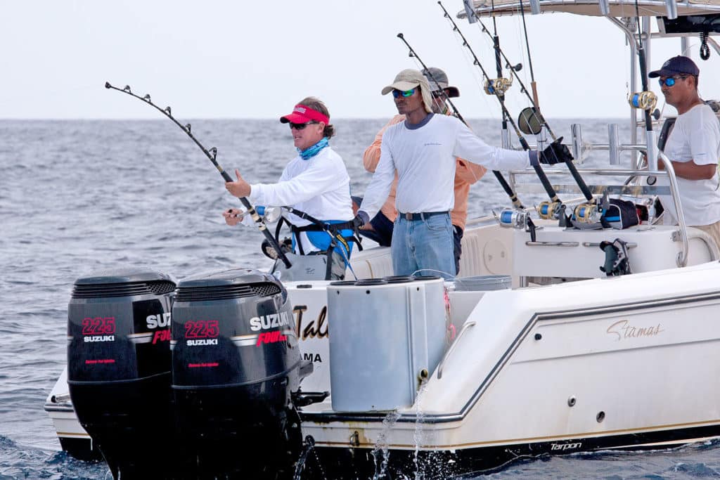 Fishermen fighting fish offshore deep sea on Stamas outboard fishing boat