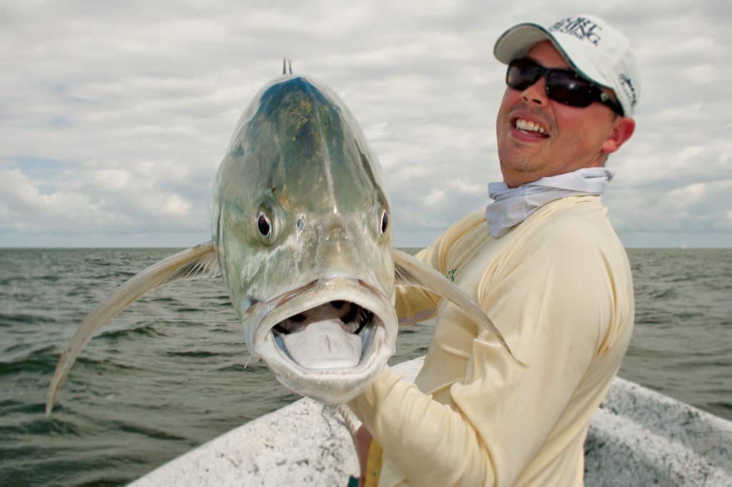 Fisherman holds jack fish caught fishing Chandeleur Islands Louisiana