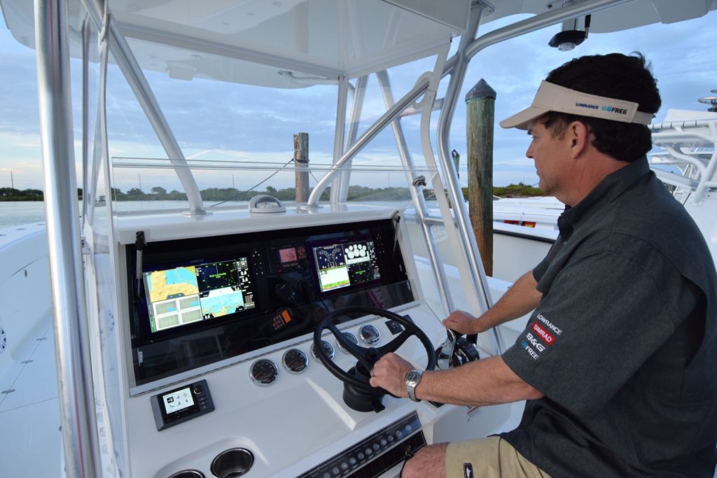 A skipper looks over vast electronics array on a center console fishing boat