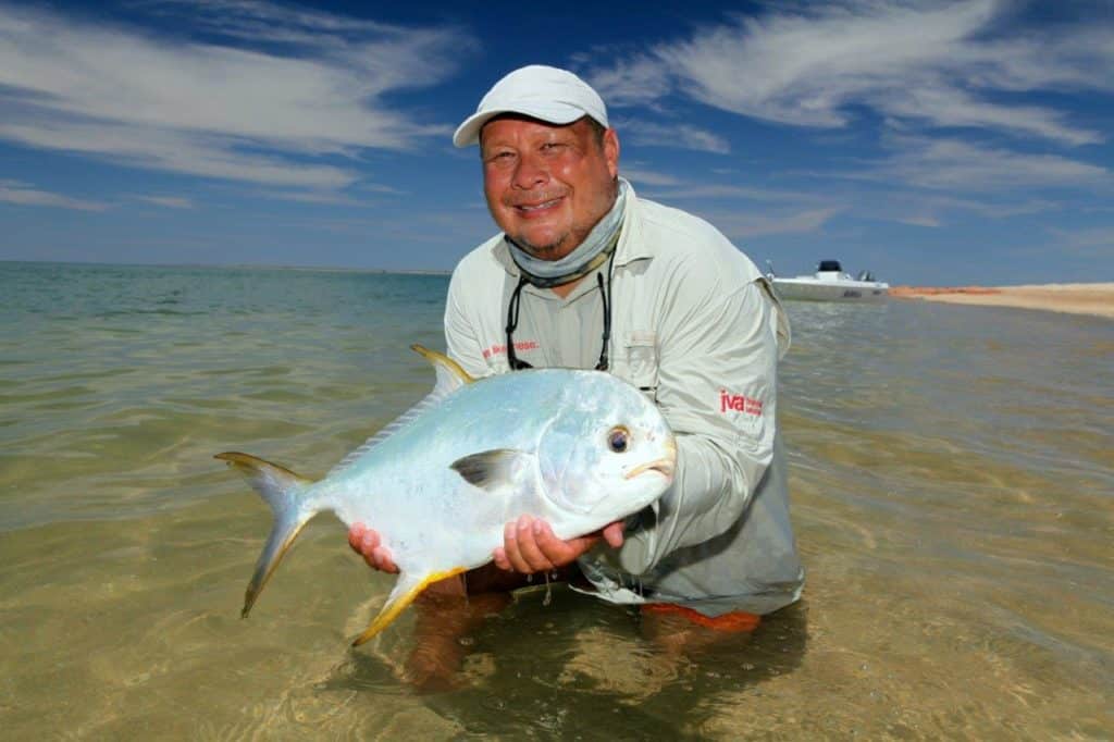 Fly-fishing angler holding a Pacific permit fish in Australia