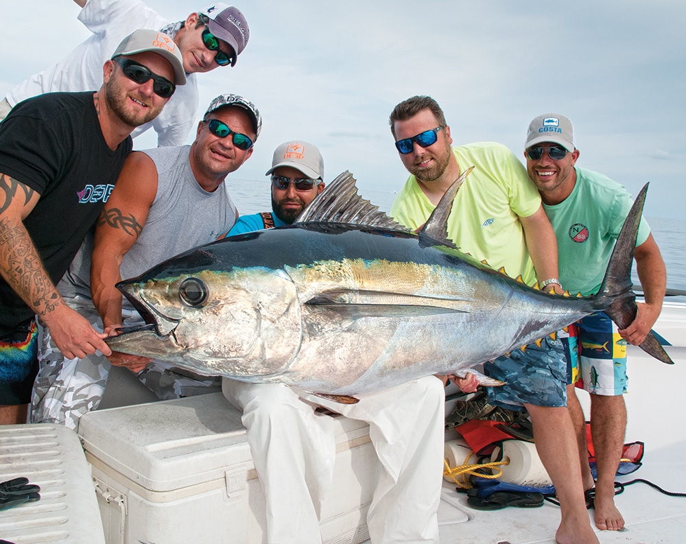 Fishermen holding giant bigeye tuna caught while bottomfishing