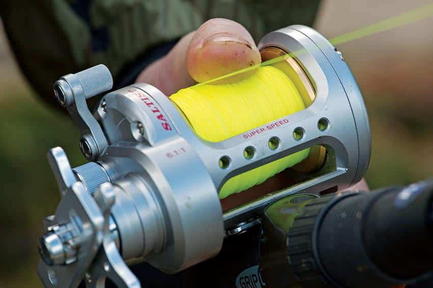 Thumbing fishing reel spool filled with line