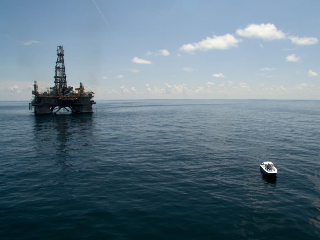 Center console fishing boat deep sea fishing around a floating oil rig in the Gulf of Mexico