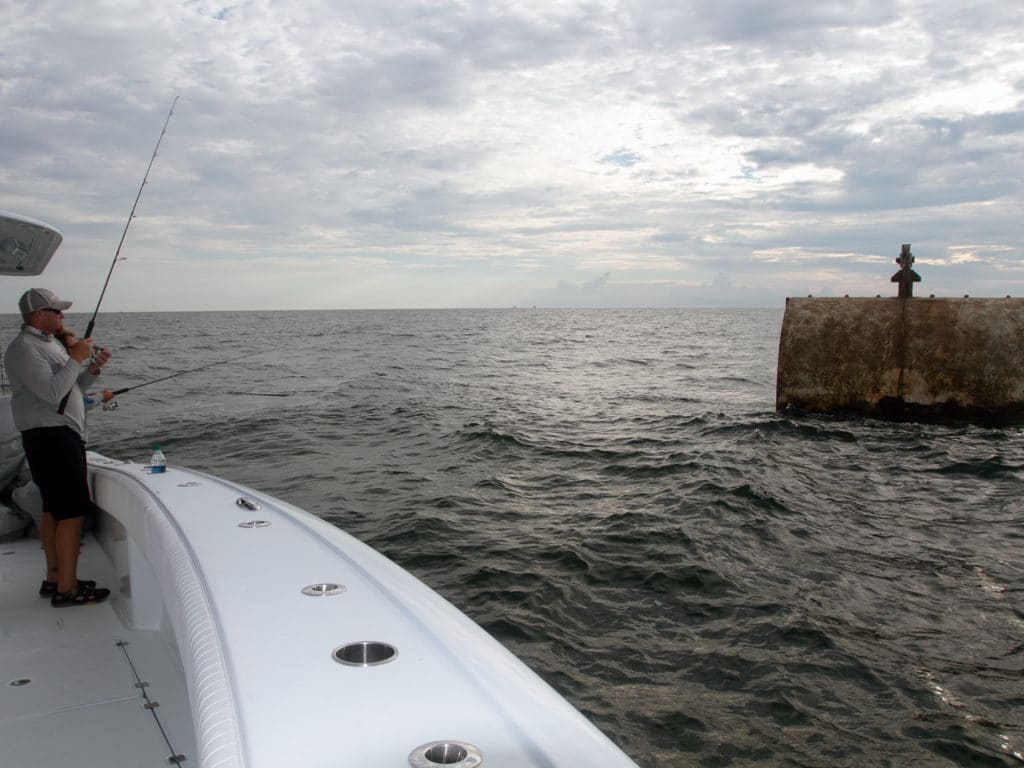 Angler on a center-console fishing boat catching bait