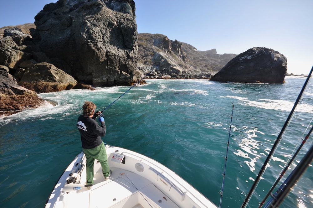 Angler saltwater fishing along breakers from boat