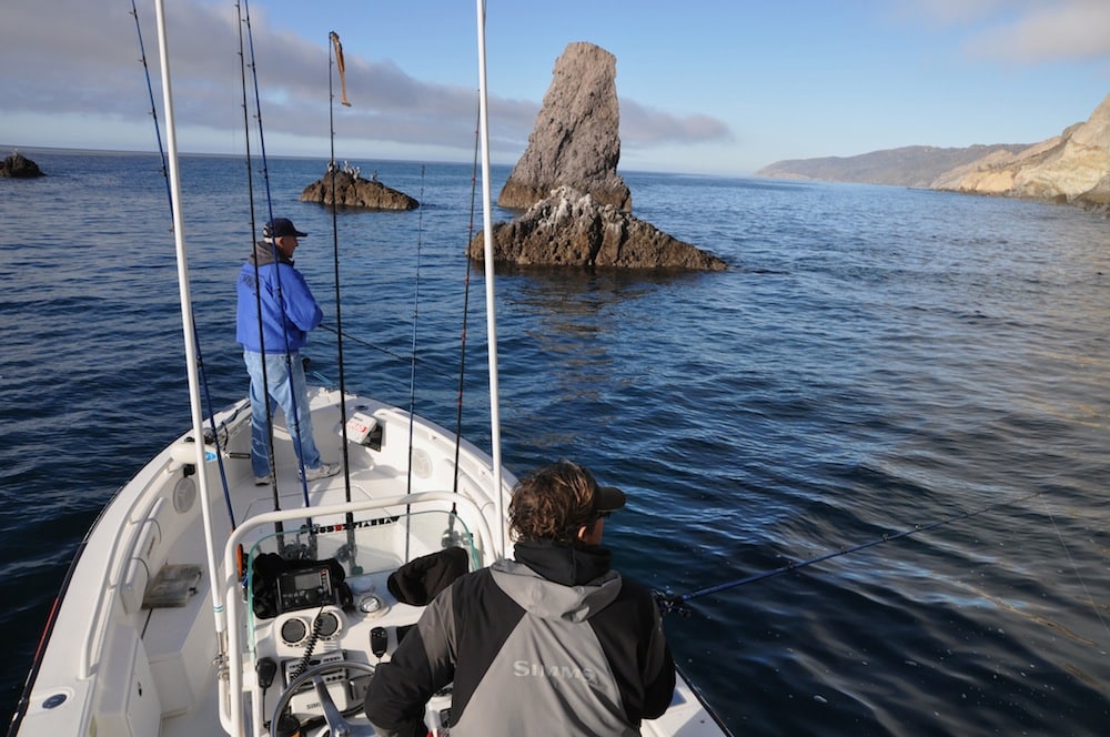 Fishermen fishing rock outcropping deep sea