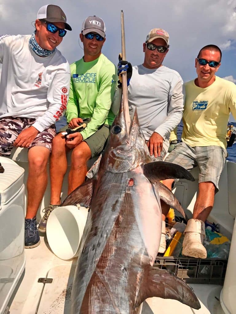 Victorious anglers with a big swordfish, on a charter with Capt. Adam Peeples, named a Top Charter Captain of the Year 2017 by Sport Fishing magazine fans