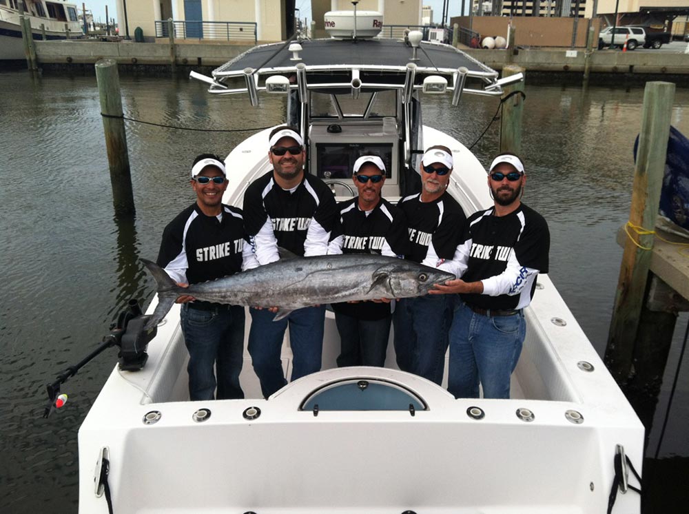 Anglers holding big fish on Onslow Bay 32 saltwater fishing boat