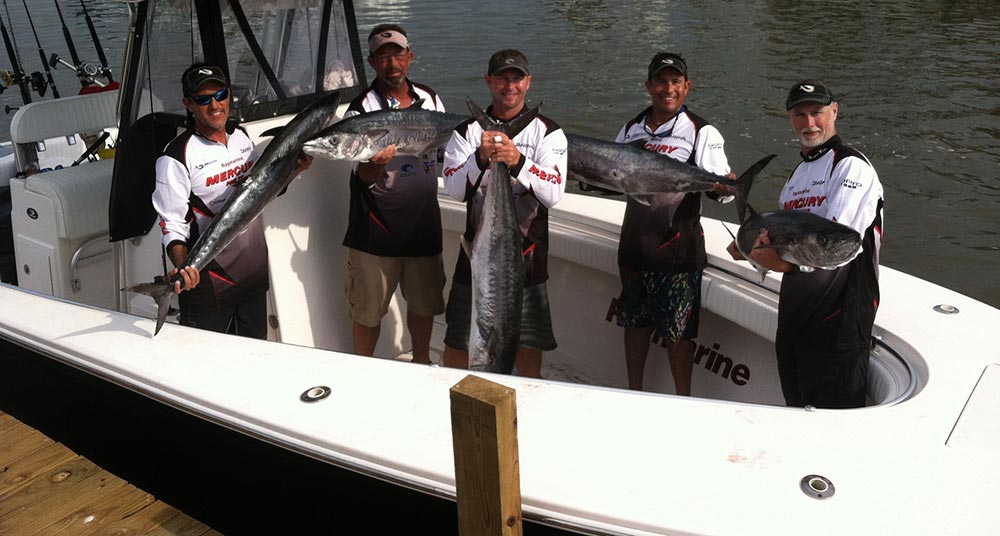 Fishermen holding fish on Onslow Bay 32 saltwater fishing boat