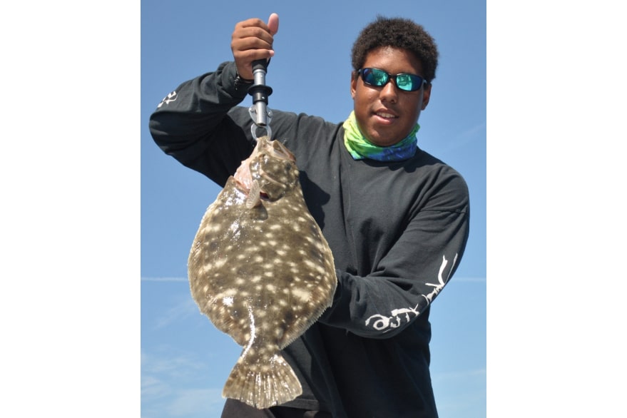 Angler holding flounder caught offshore deep sea fishing
