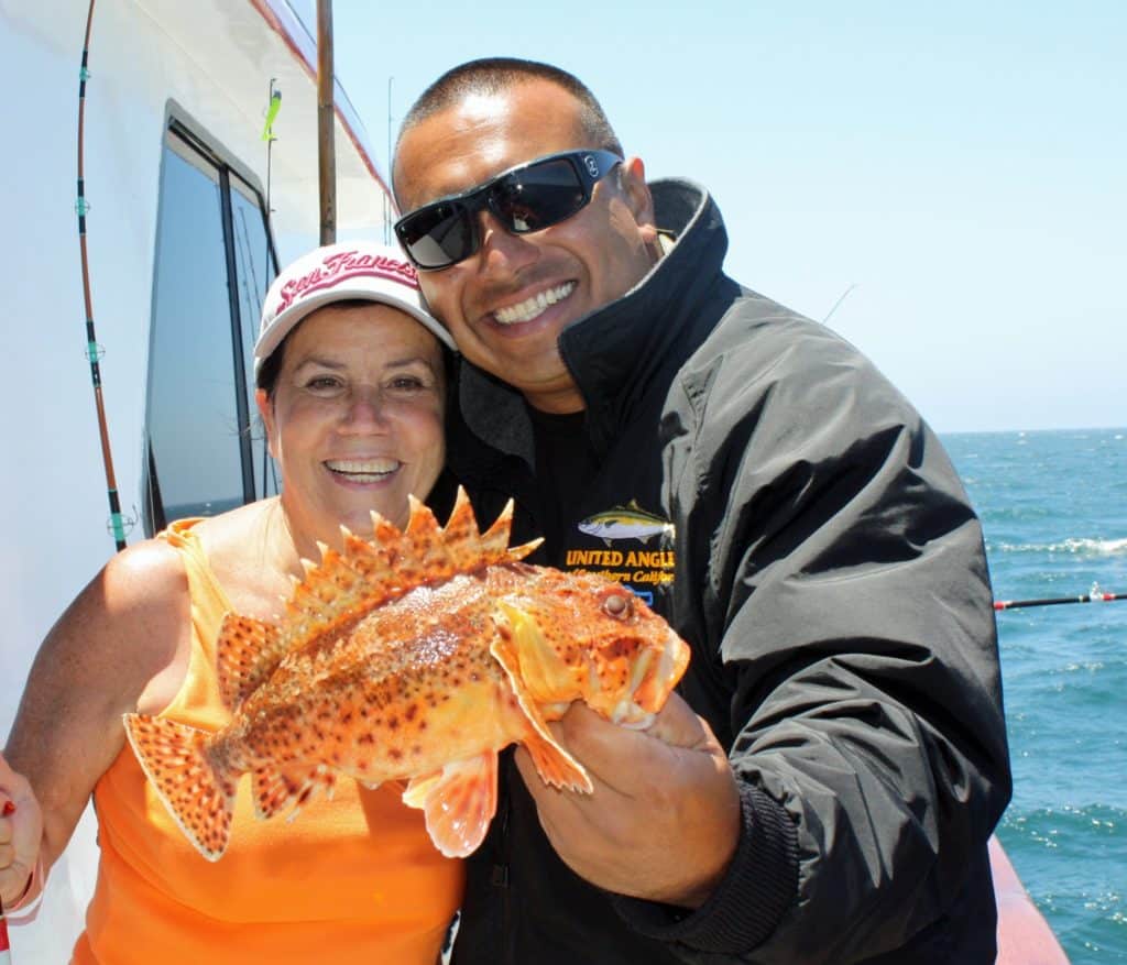 Two anglers holding a sculpin caught fishing on rod and reel