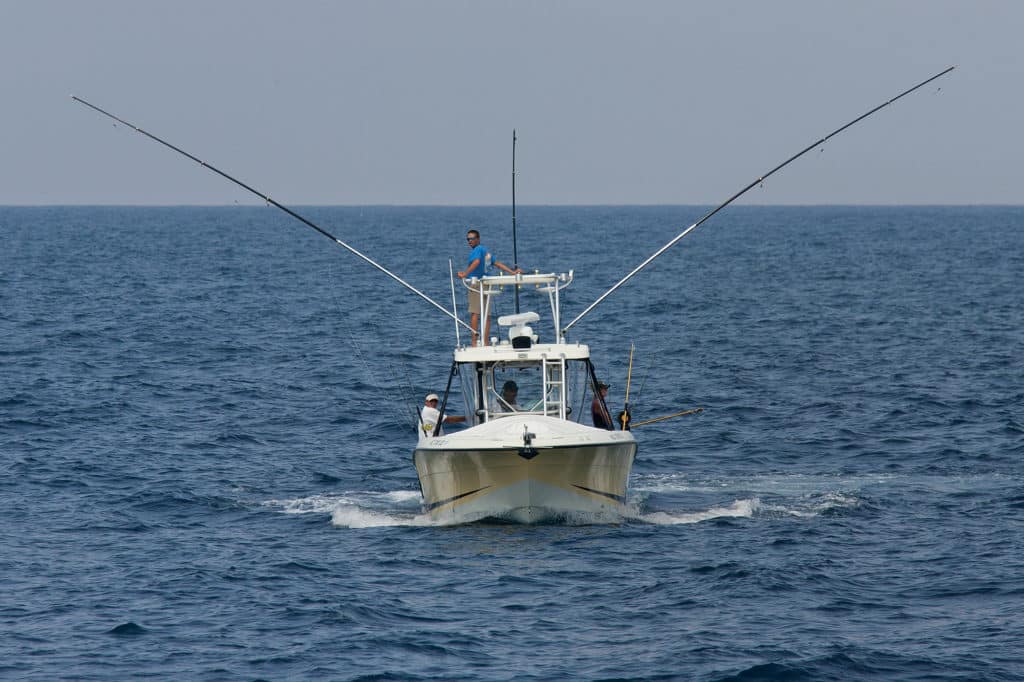 Small fishing boat outriggers and downriggers deployed