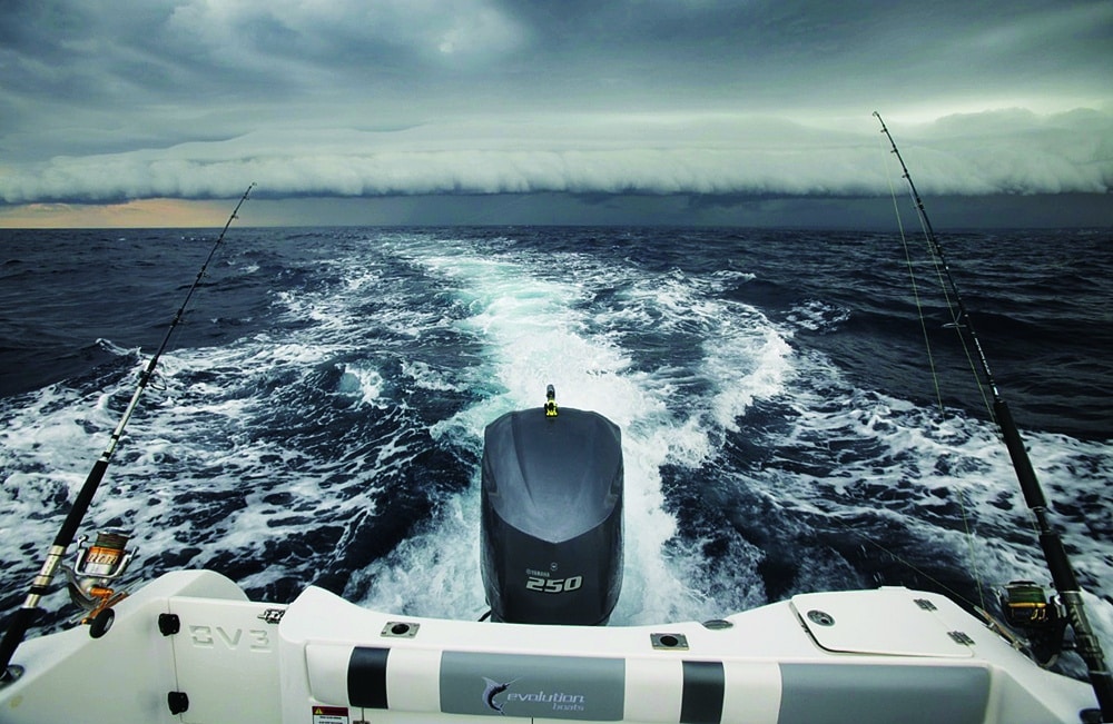 Fishing boat speeding away from bad weather storm