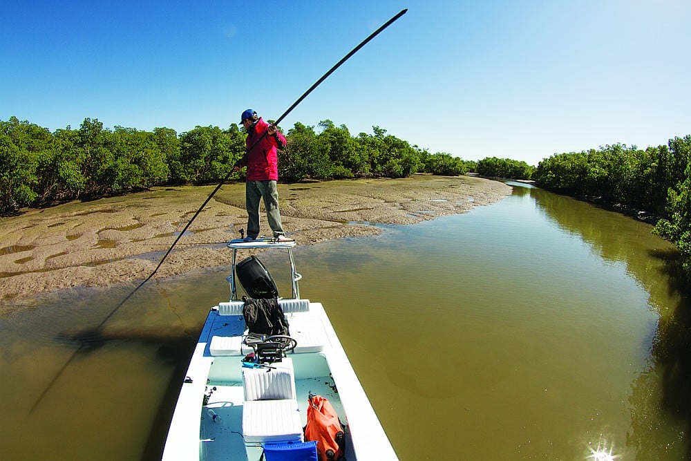Fisherman polling a technical skiff boat fishing Everglades Florida