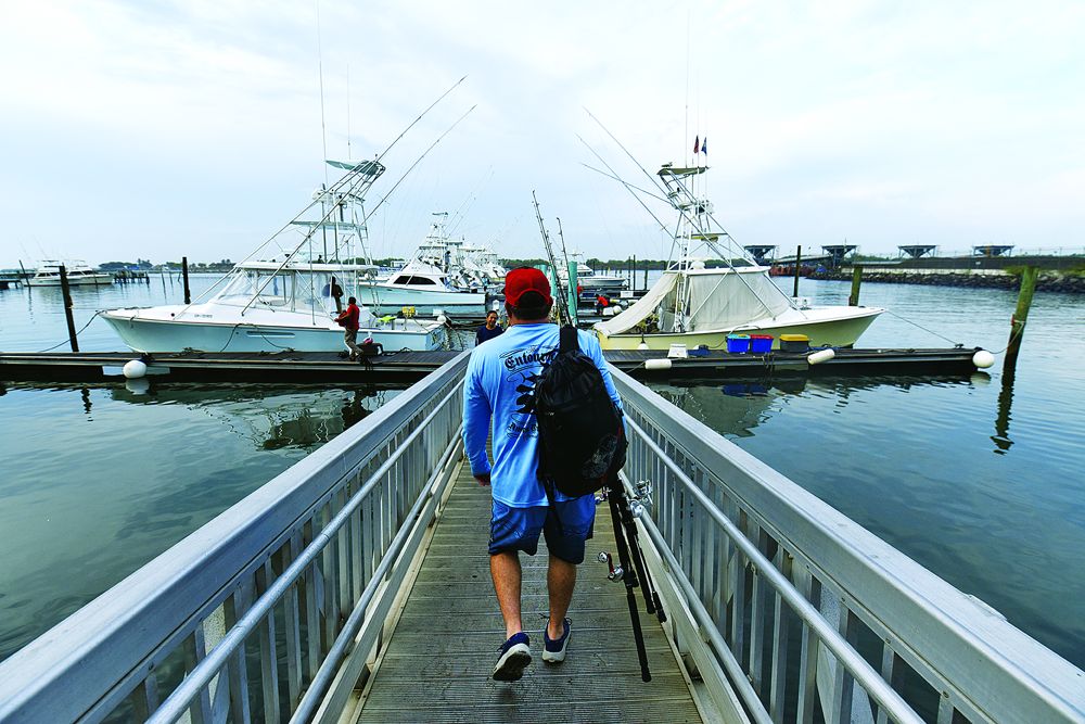 An angler heads down the dock to the waiting sport-fishing fleet in Guatemala