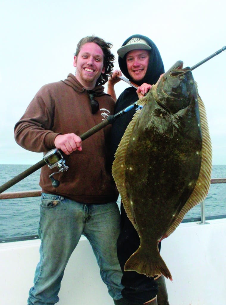 Anglers holding giant California halibut caught fishing Channel Islands