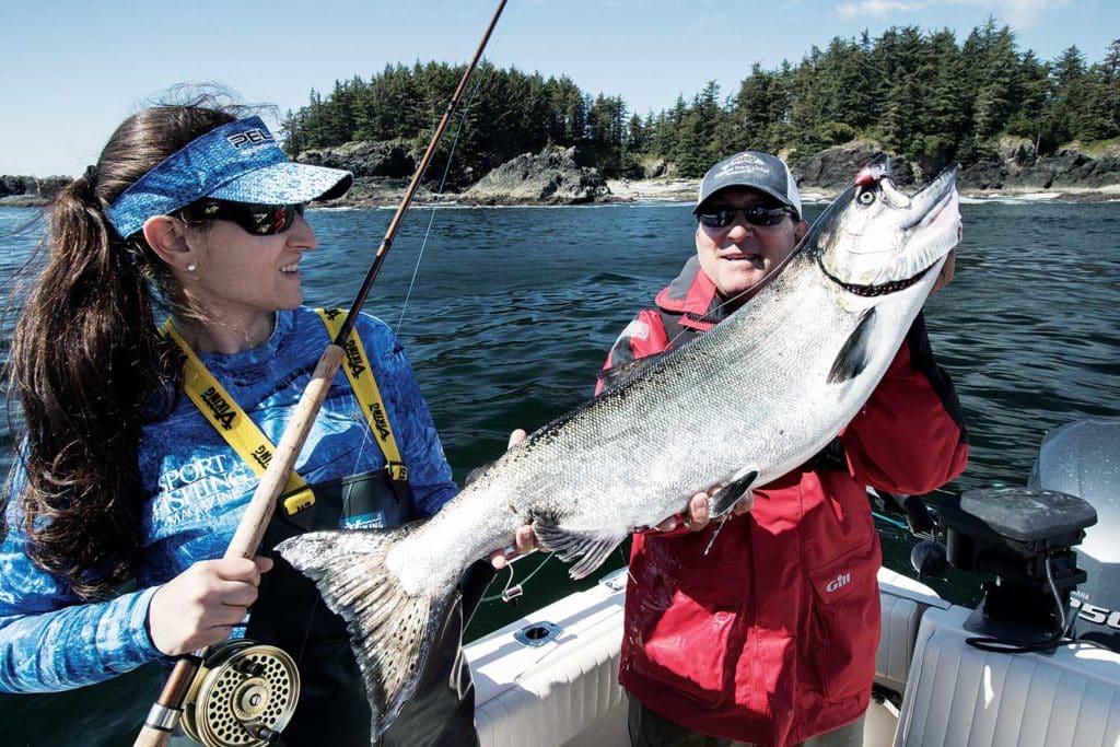 Angler admires salmon she caught on mooching tackle.