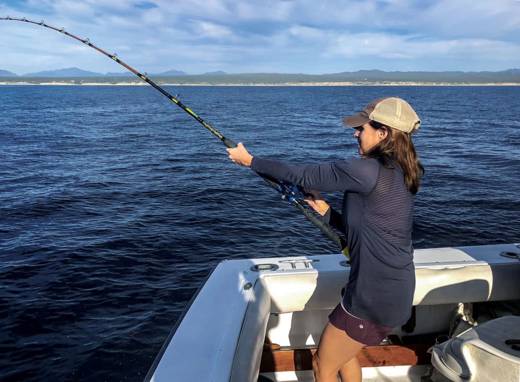 Woman catching fish on offshore charter