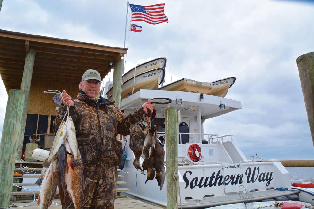 Angler holding redfish after duckhunt