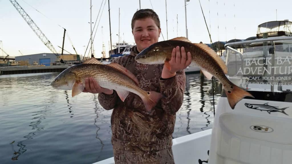 Angler holding redfish fishing Gulf of Mexico