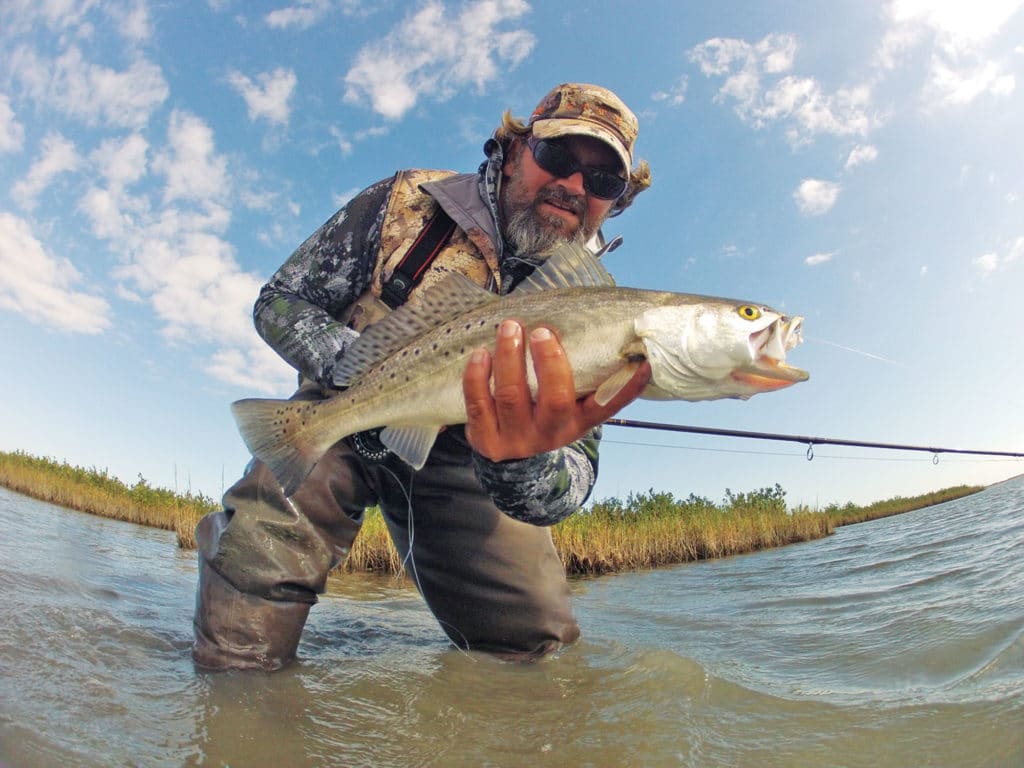 Fisherman wading spotted seatrout fishing