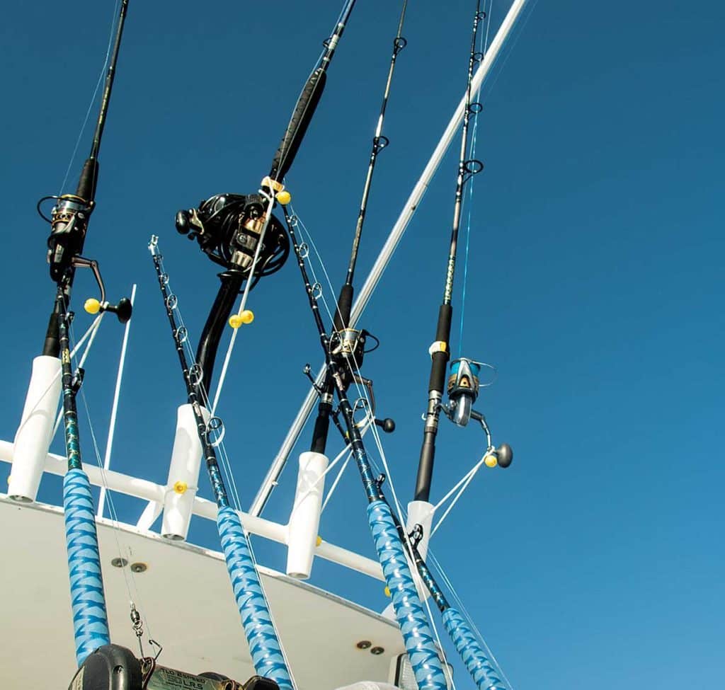 Fishing Rods Hanging From Back Of Boat Facing Mountains In